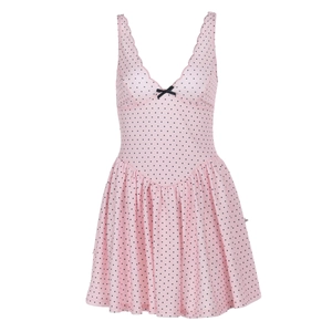 Detailed view of pink polka dot dress featuring V-neckline and small black bow detail