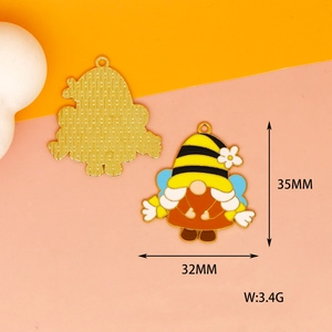 Detail of bee gnome enamel pendant showing colorful front and golden textured back