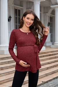 Detailed close-up of wine red knit maternity sweater with a ribbed texture and waist belt