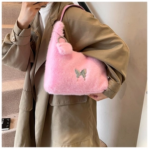 Detail of pink plush tote bag with silver butterfly pendant and leather strap