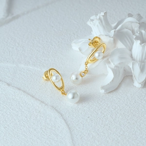 Detailed shot of s925 silver pearl drop earrings with 18k gold plating and zircon stone