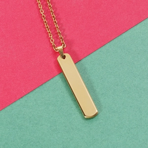 Collana con pendente a barra in acciaio inossidabile dorato su sfondo minimale