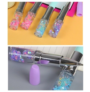Detail of creative lipstick-shaped pens with colorful liquid glitter inside the barrel