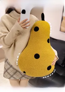 Macro detail of plush pear pillow with yellow sherpa texture and black polka dots