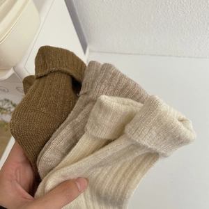 Detailed close-up of thick ribbed knit wool socks in brown and beige tones