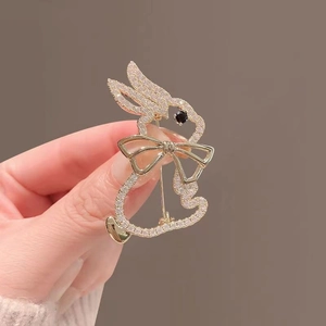 Detail of a golden rabbit brooch featuring sparkling zircon and a black gemstone eye