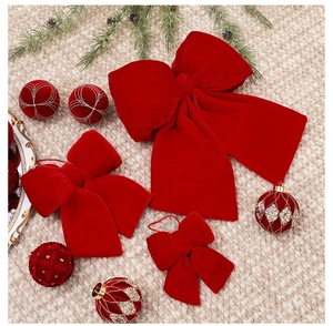 Macro detail of red velvet Christmas bows in various sizes on a woven textured background