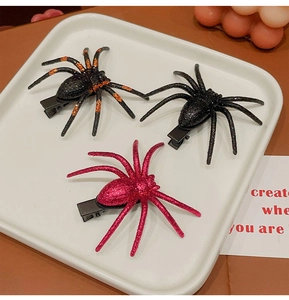Detail of glitter spider hair clips in black, orange and pink for Halloween party costume