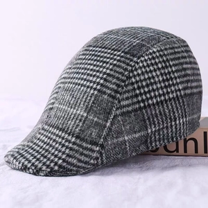 Close-up of the classic black and gray plaid newsboy cap with premium wool texture