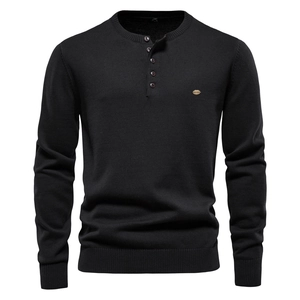 Close-up of knit sweater with Henley neck button design and small metal logo detail