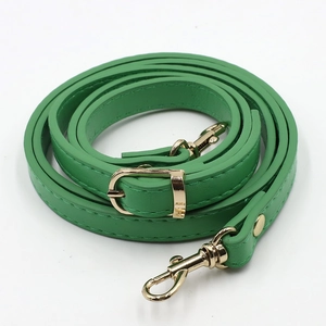 Detailed macro shot of a bright green PU leather adjustable shoulder strap with gold buckles