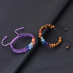 Dettaglio di braccialetti chakra regolabili con perle di ametista e occhio di tigre
