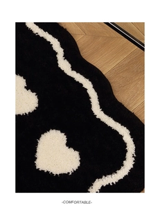 Macro detail of plush tufted bathroom mat showing soft wavy lines and heart pattern