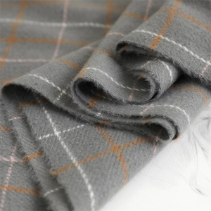Macro view of grey cashmere-like plaid scarf with soft orange and white checkered weave