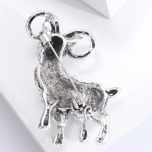 Macro shot of silver vintage-style brooch back showing safety pin and pearl edge details