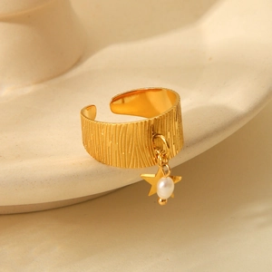 Detail of 18K gold plated steel ring with star charm, pearl bead and textured surface