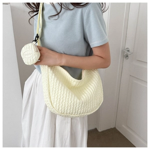 Detail of yellow seersucker crossbody bag with a round coin purse and wave texture
