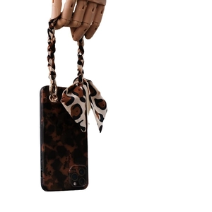 Leopard print iPhone case with matching silk scarf hand strap on a wooden hand model