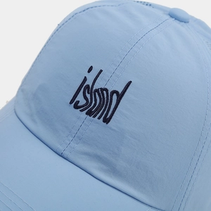 Close-up of quick-dry baseball cap in light blue featuring island embroidery and reinforced stitching