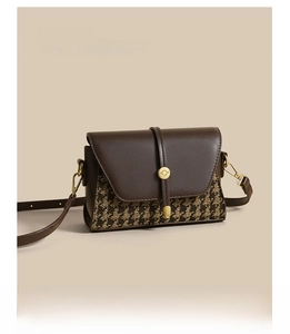 Detail of premium houndstooth fabric and leather stitching on luxury crossbody bag