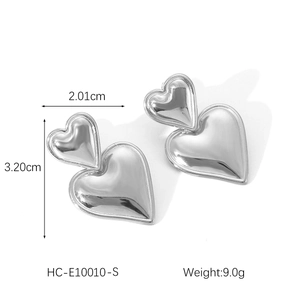 Detail view of heart-shaped steel earrings with 2.01cm width and 3.20cm height specs