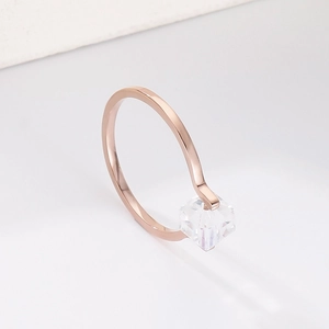 Macro detail of minimalist rose gold ring featuring a clear square zircon crystal inlay
