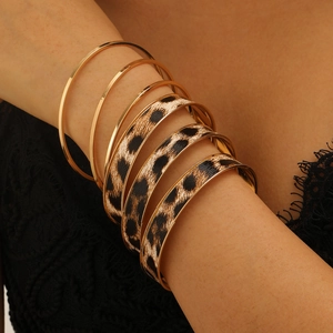 Close-up of vintage gold polished bracelets with striking leopard pattern bangles