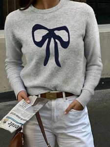 Street style view of grey knit short sleeve sweater with a black bow print