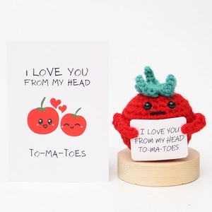Detail of hand-knitted red tomato doll on wood base with a I Love You greeting card