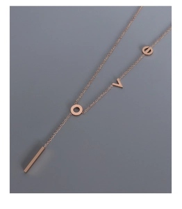Macro detail of rose gold LOVE letter pendant necklace with fine polished link chain