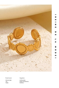 Detail of a matte gold geometric ring with interconnected circular discs on stone surface