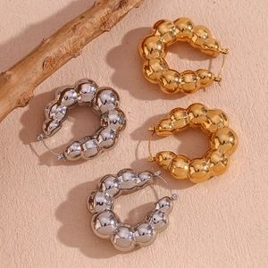 Detailed view of chunky ball chain hoop earrings in polished gold and silver finishes
