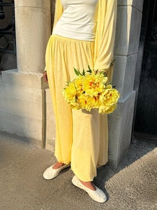 Detail of light yellow knit long cardigan and wide-leg pants set with breathable texture