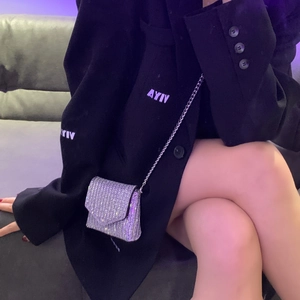 Mini silver rhinestone evening bag with chain strap shown on black blazer sleeve