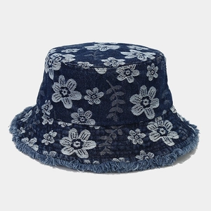 Close-up of floral jacquard pattern and frayed edges on denim bucket hat fabric