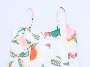 Gros plan sur l'imprimé de fruits tropicaux sur robe d'été blanche à bretelles