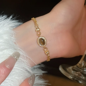 Détail macro d'un bracelet vintage doré orné d'un oeil de tigre brun et de zircons