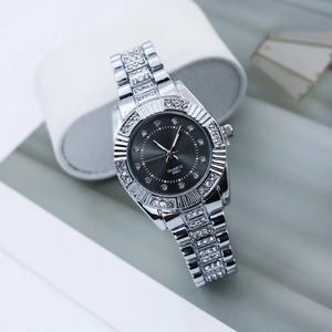 Gros plan d'une montre à quartz argentée avec strass et cadran gris foncé brossé