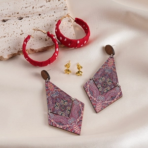 Detailed view of red polka dot fabric hoop and vintage wooden diamond drop earrings