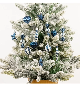 Close-up of 13-piece dark blue Christmas ornaments hanging on a snowy Christmas tree