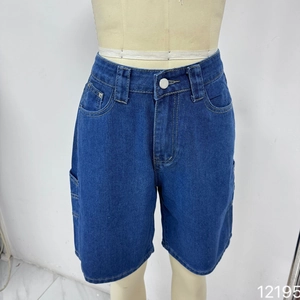 Dettaglio dei pantaloncini di jeans blu scuro con cuciture arancioni a contrasto e stelle