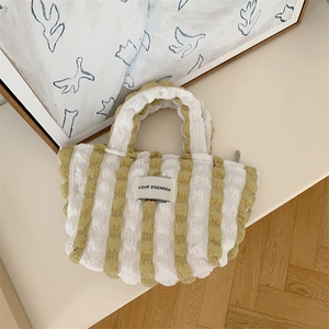 Detail of yellow and white striped bubble fabric handbag with Love Sozakka label
