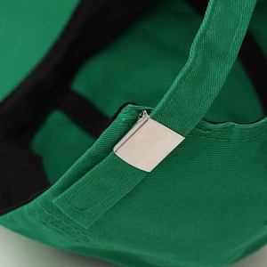 Detail of green baseball cap featuring adjustable strap and silver metal buckle closure
