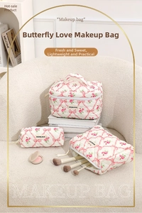 Three-piece quilted makeup bag set with pink bows and floral rose patterns in cream white
