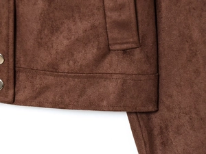 Detail shot of brown faux suede jacket featuring fine stitching and silver metal button