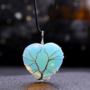 Macro shot of silver wire tree of life wrapped on a blue heart opal stone pendant