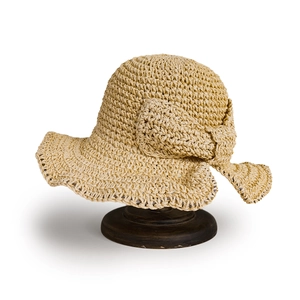 Détail de la texture d'un chapeau de paille tressé et d'un nœud élégant sur support
