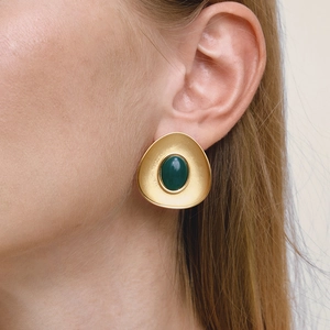 Vintage matte gold resin earrings with emerald green stone worn by a female model