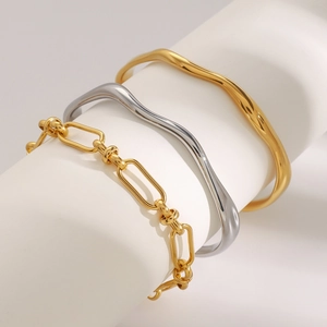 Minimalist gold and silver bracelets on a display stand with high mirror finish