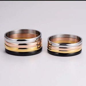 Detail of four-color minimalist stainless steel bracelets in polished and brushed finishes
